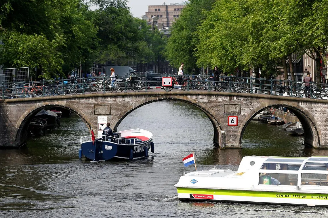 Tourists boats pass on a canal in Amsterdam, Netherlands, May 16, 2018. Picture taken May 16, 2018.  REUTERS/Francois Lenoir/ File Photo