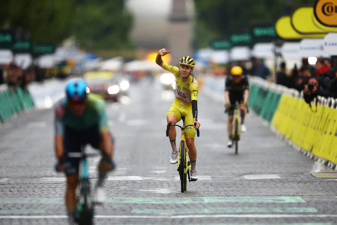 Cycling - Tour de France - Stage 21 - Mantes-la-Ville to Paris - Paris, France - July 27, 2025 UAE Team Emirates XRG's Tadej Pogacar celebrates as he crosses the finish line while wearing the yellow jersey after stage 21 to win the Tour de France REUTERS/Sarah Meyssonnier