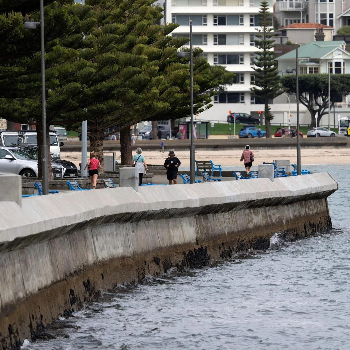 People walk and jog on Oriental Parade in Wellington, New Zealand, September 24, 2025. REUTERS/Marty Melville