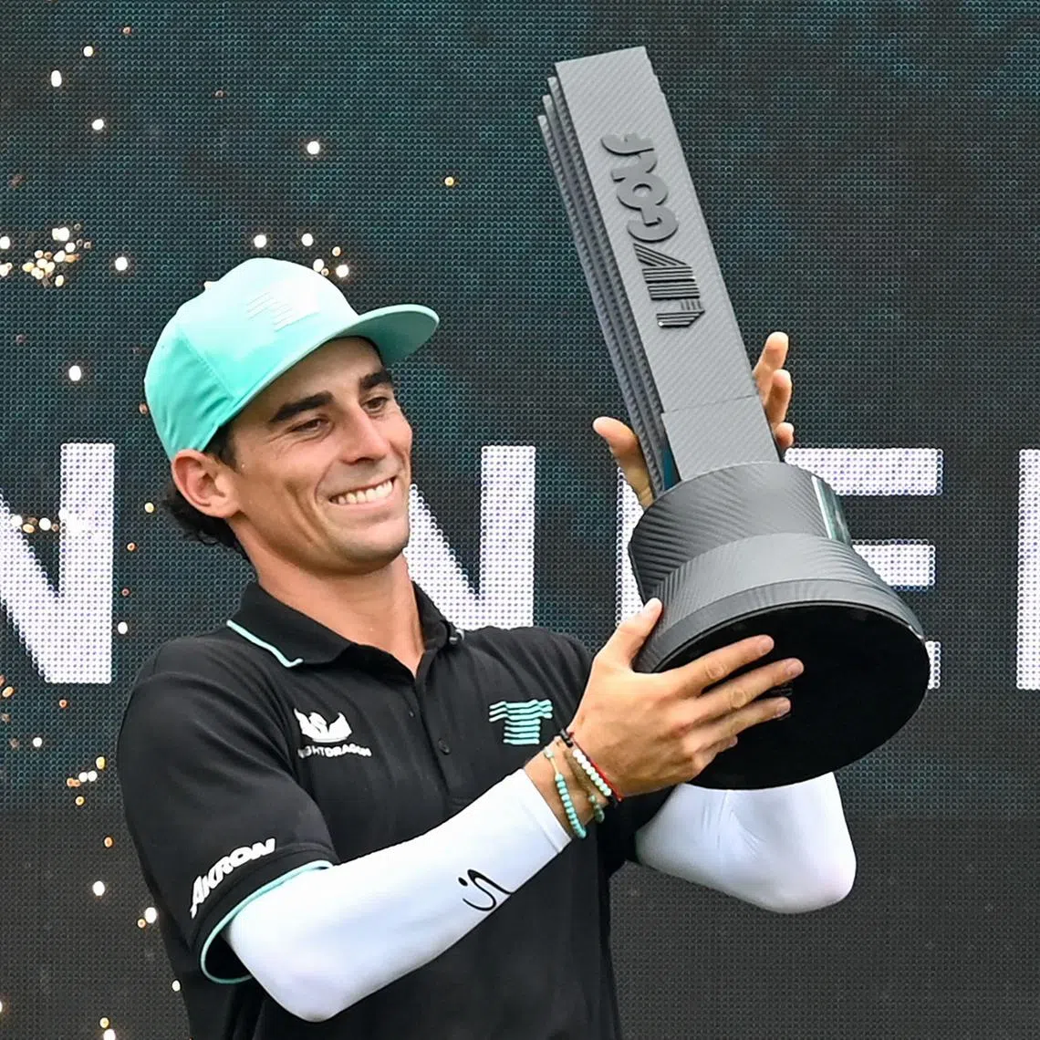 Chile's Joaquin Niemann of Torque GC team lifts the trophy after winning the individual final round of the LIV Golf Singapore at Sentosa Golf Club on March 16, 2025. (Photo by Roslan RAHMAN / AFP)