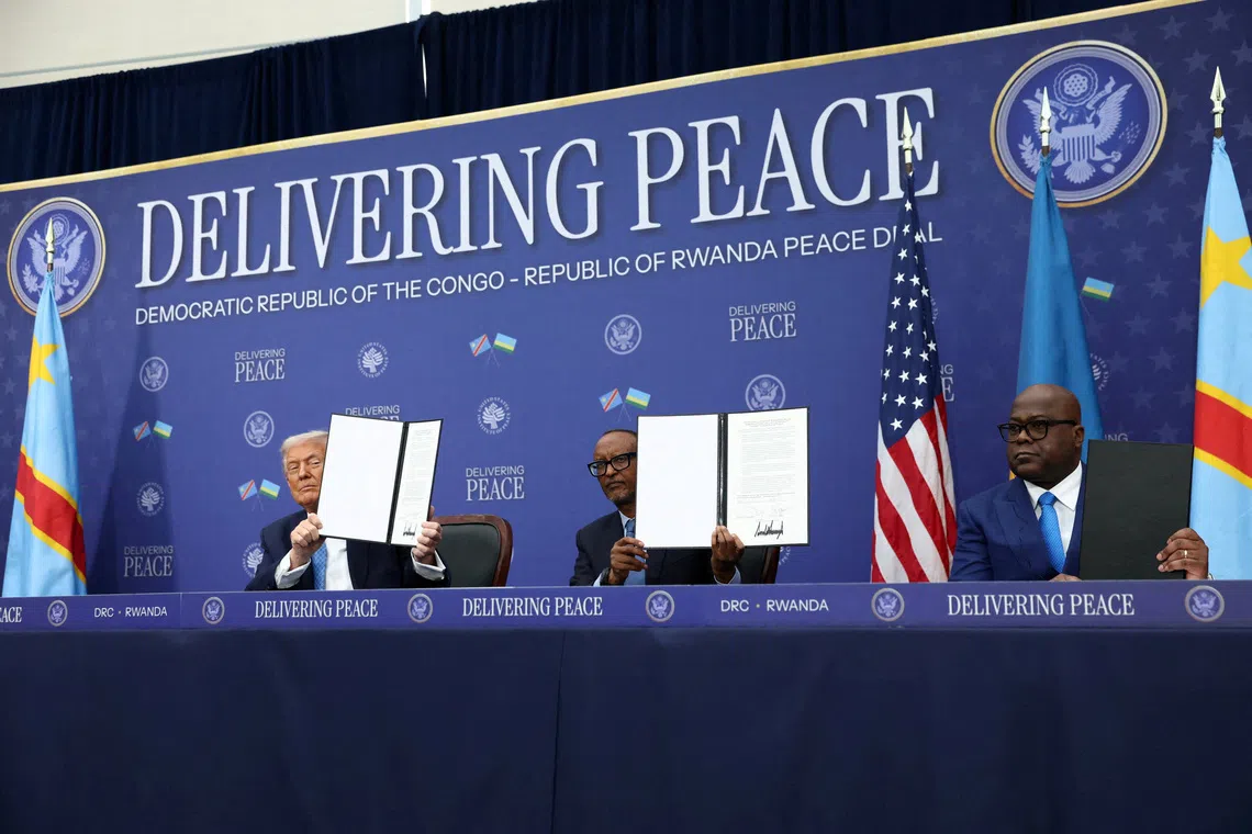 FILE PHOTO: U.S. President Donald Trump, President of the Democratic Republic of the Congo Felix Tshisekedi and President of Rwanda Paul Kagame hold a signed document during a signing ceremony at the U.S. Institute of Peace in Washington, D.C., U.S., December 4, 2025. REUTERS/Kevin Lamarque/File Photo