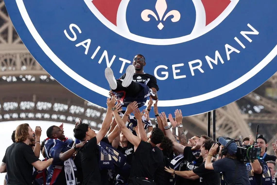 Paris Saint-Germain players lifting Ousmane Dembele in the air on May 31, as they celebrate winning the UEFA Champions League.