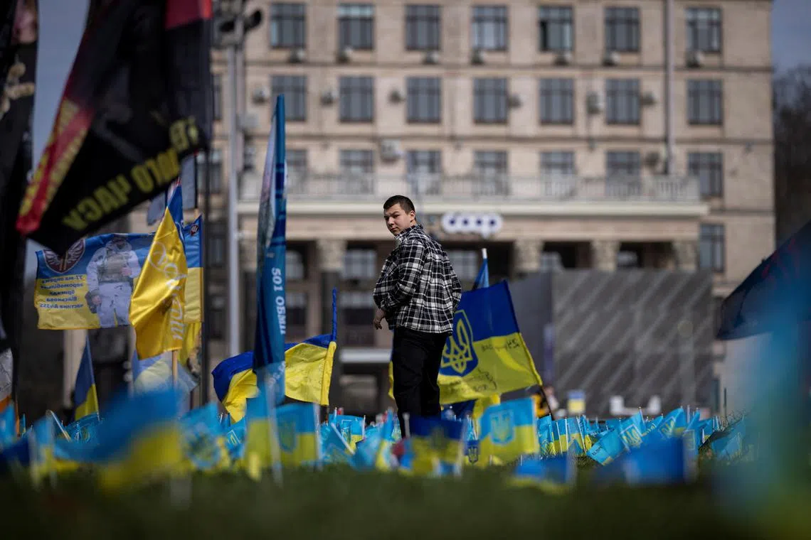 FILE PHOTO: A man walks past Ukrainian flags at a memorial commemorating fallen servicemen who fought against Russia’s  invasion of Ukraine, in Khreshchatyk Street in Kyiv, Ukraine, April 2, 2024. REUTERS/Thomas Peter/File Photo