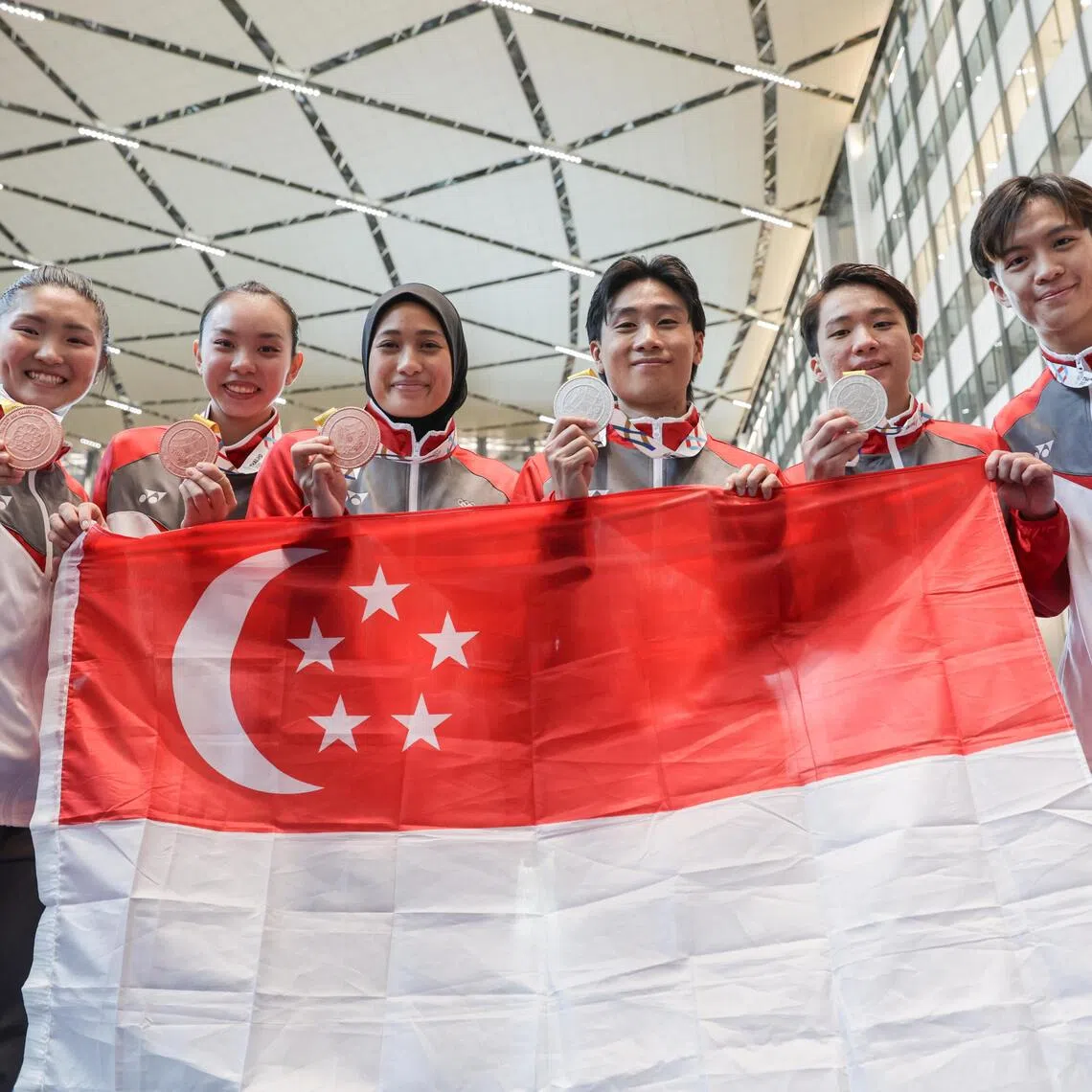 Singapore’s wushu medalists pose for a photo with their medals on Dec 15, 2025. Kassandra Ong, Le Yin Shue, Siti Khadijah Binte Mohamad Shahrem, Tay Yu Xuan, Randall Lin and Chan Jun Kit won two silver and four bronze medals for Singapore.