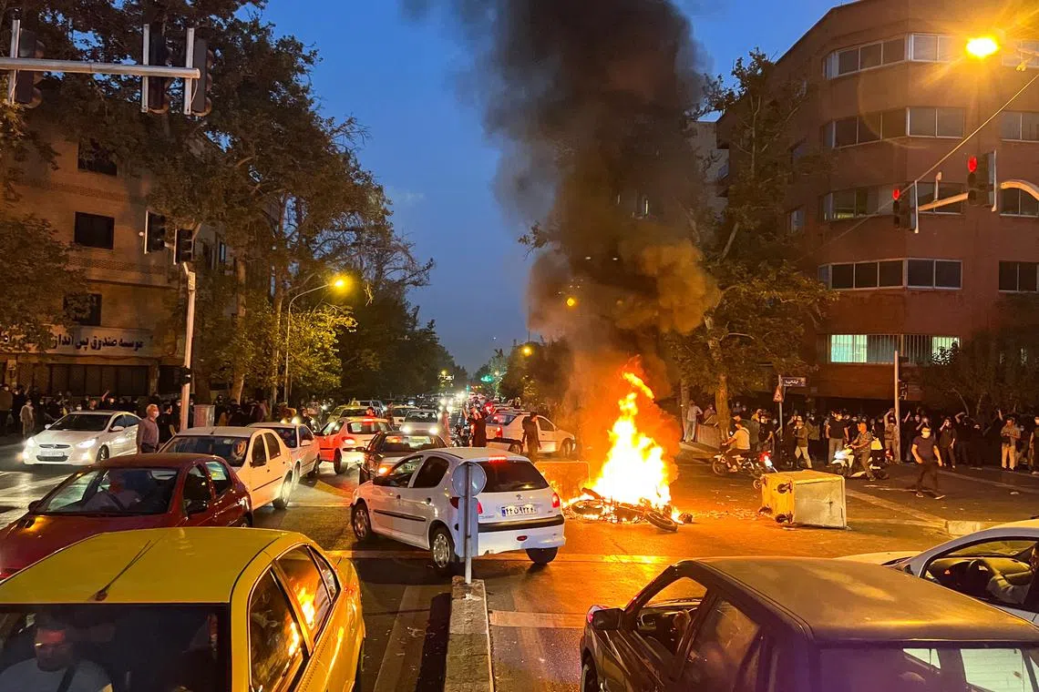 FILE PHOTO: A police motorcycle burns during a protest over the death of Mahsa Amini, a woman who died after being arested by the Islamic republic's \"morality police\", in Tehran, Iran September 19, 2022. WANA (West Asia News Agency) via REUTERS/File Photo