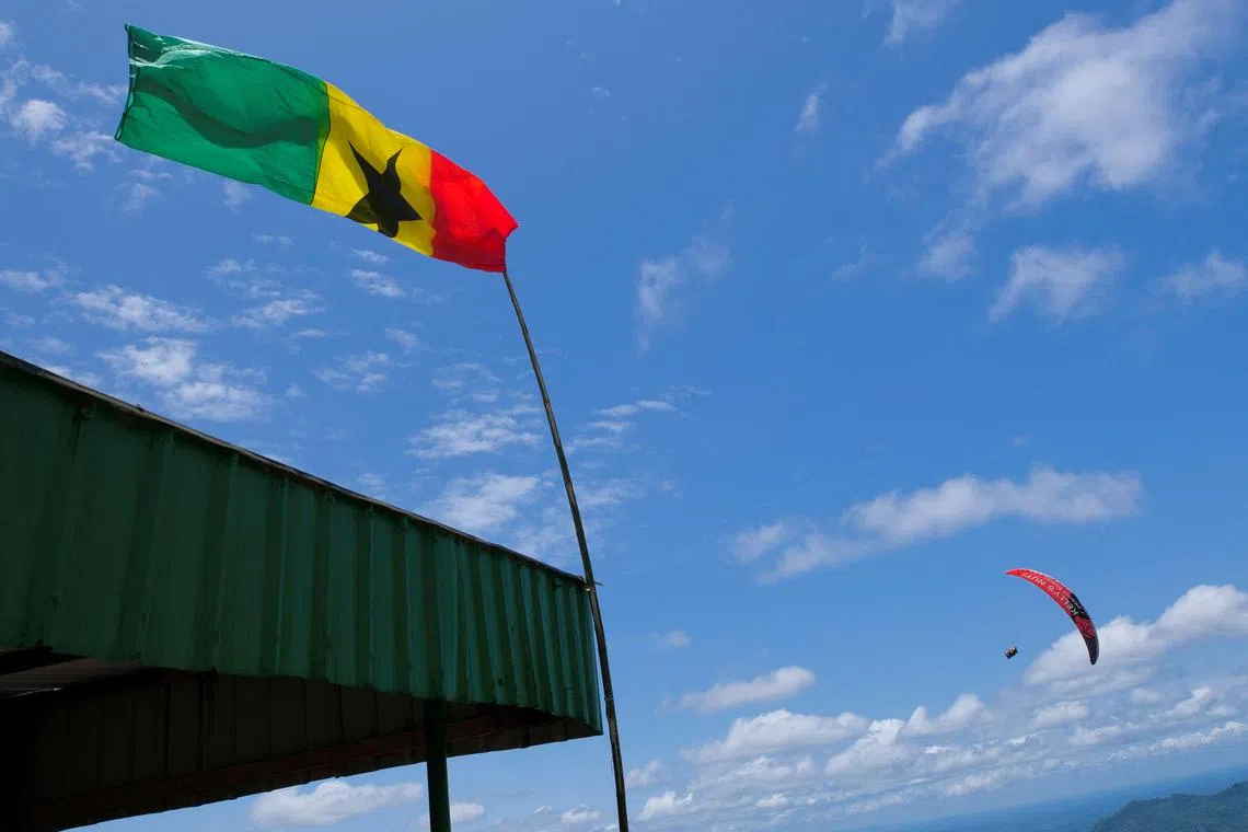 FILE PHOTO: Ghana's flag is seen while a paraglider is traversing the Nkawkaw town skies in Kwahu-Atibie, Ghana April 15, 2022. REUTERS/Francis Kokoroko