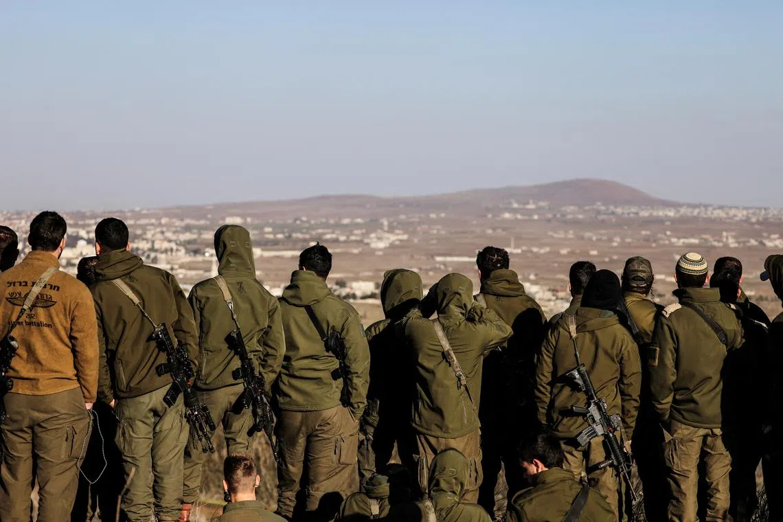 FILE PHOTO: Israeli soldiers look into Syria, after the ousting of Syria's Bashar al-Assad, in Ein Zivan in the Israeli-occupied Golan Heights, December 25, 2024. REUTERS/Jamal Awad/File Photo