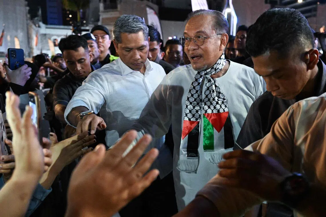 Malaysia's Prime Minister Anwar Ibrahim (centre) arrives during a rally and flags off Gaza aid mission in Kuala Lumpur on Aug 24, 2025.