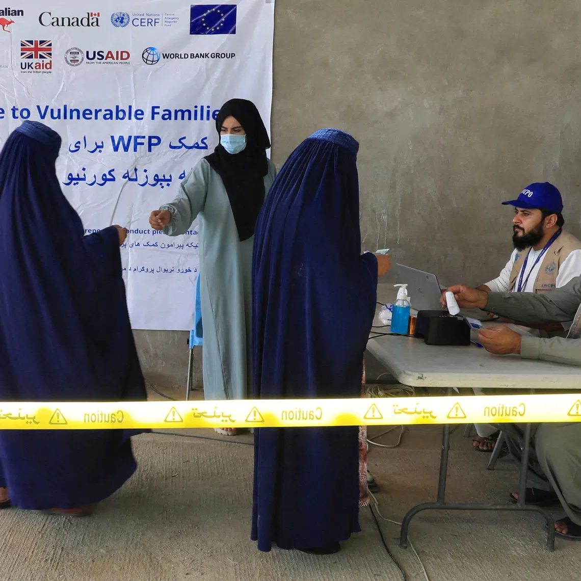 FILE PHOTO: Afghan women arrive to receive assistance from a World Food Program (WFP) distribution centre in Kabul, Afghanistan, August 21, 2024. REUTERS/Sayed Hassib/File Photo