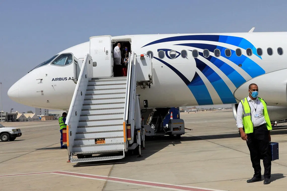 FILE PHOTO: An employee of Luxor's International Airport, wearing a protective face mask, walks next to an EgyptAir plane in Luxor, Egypt April 9, 2021. REUTERS/Amr Abdallah Dalsh/File Photo