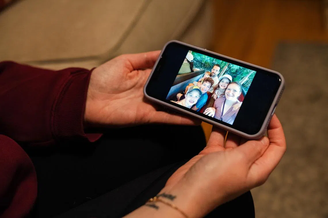 Elizabeth Seal shows a family photo with her husband, Joshua Seal.