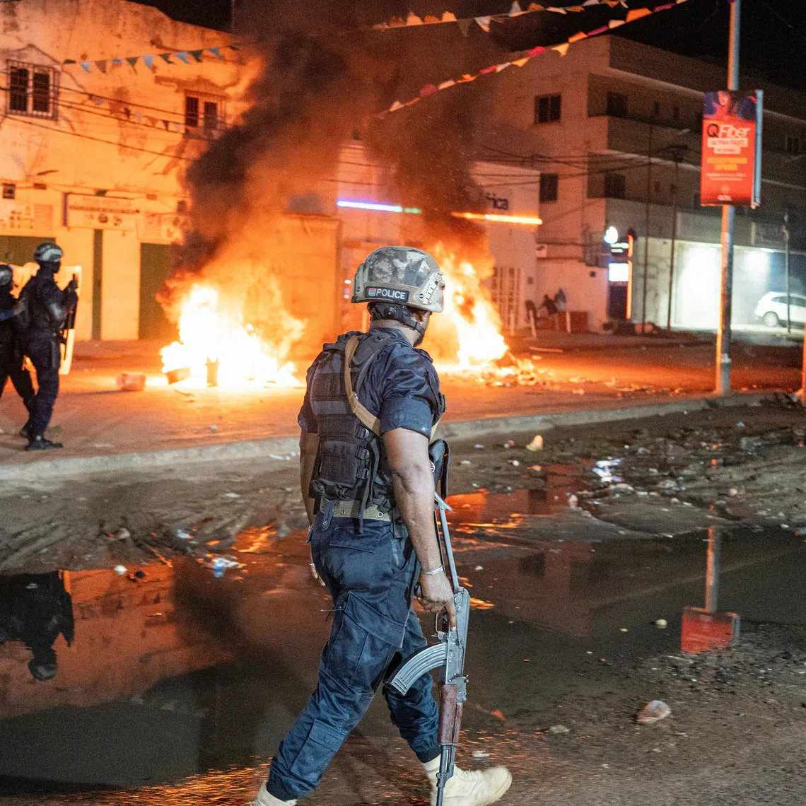 Police officers patrol near burning barricades as residents protest against power and water cuts in Banjul, Gambia, September 8, 2026. REUTERS/Malick Njie