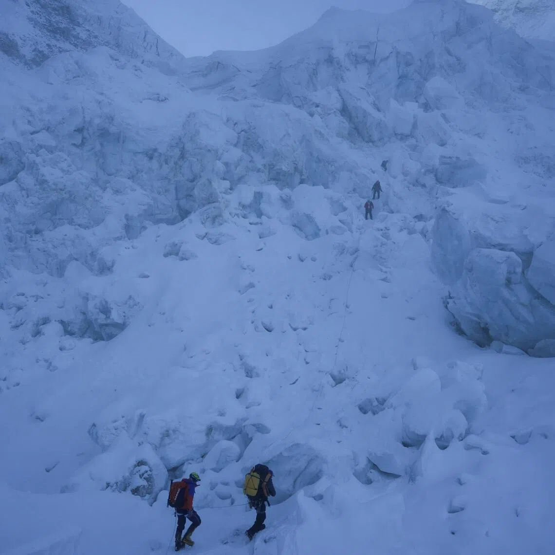 Members of an expedition team climb through the Khumbu Icefall during their rotation trip from Everest Base Camp to Camp 1 in the Solukhumbu district, also known as the Everest region.