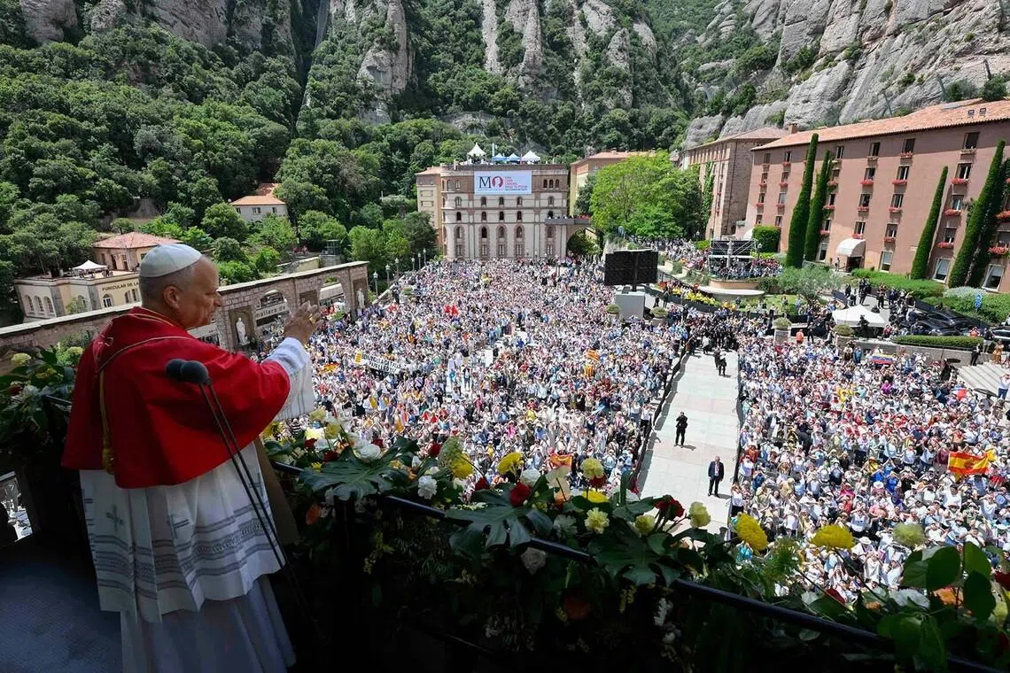 Pope Leo XIV waving from a balcony after the recitation of the Rosary at the Abbey of Our Lady of Montserrat, near Barcelona, June 10. 
