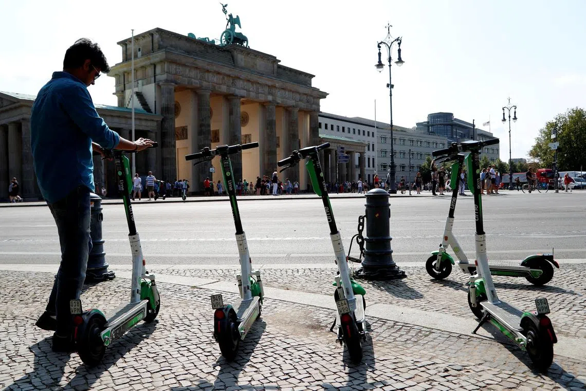 FILE PHOTO: E-scooters of California-based bicycle service Lime are pictured by the Brandenburg Gate in Berlin, Germany, August 8, 2019. REUTERS/Fabrizio Bensch/File Photo
