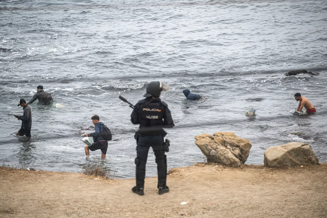 FILE PHOTO: Migrants swim at El Trampolin beach heading to the nearby El Guano, an immigrants' settlement, as Police clear up an encampment of migrants at El Trampolin beach in the Spanish enclave of Ceuta, in Ceuta, Spain, October 4, 2026. REUTERS/Marcos Moreno