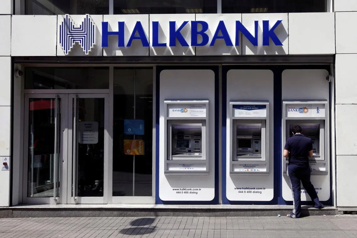 FILE PHOTO: A customer uses an automated teller machine at a branch of Halkbank in Istanbul August 15, 2014.  REUTERS/Osman Orsal/File Photo