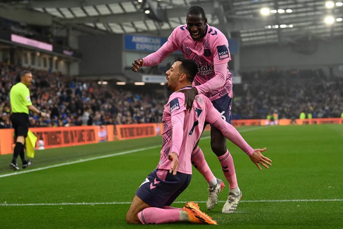 Everton's England midfielder Dwight McNeil (centre) celebrates with Everton's French midfielder Abdoulaye Doucoure.