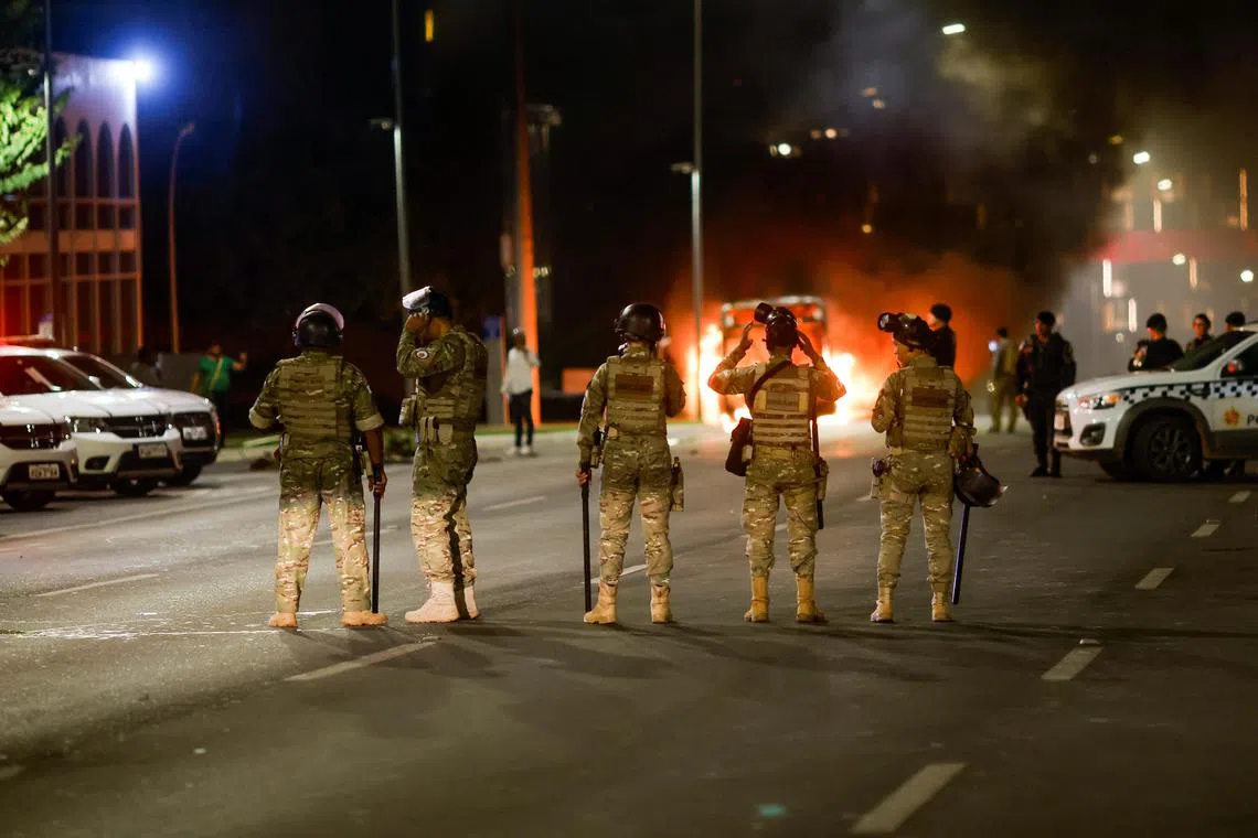 Members of the military stand guard as supporters of Brazil's President Jair Bolsonaro protest after supreme court justice Alexandre de Moraes ordered a temporary arrest warrant of indigenous leader Jose Acacio Serere Xavante for alleged anti-democratic acts, in Brasilia, Brazil, December 12, 2022.  REUTERS/Adriano Machado 
