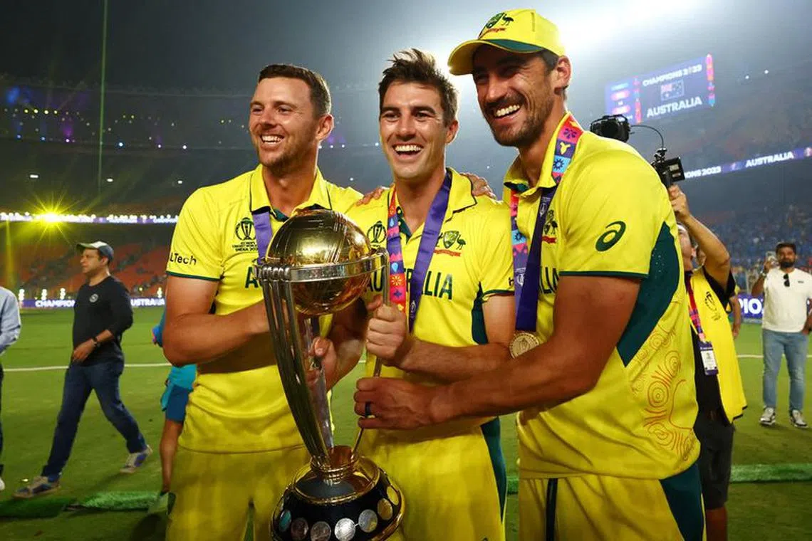 FILE PHOTO: Cricket - ICC Cricket World Cup 2023 - Final - India v Australia - Narendra Modi Stadium, Ahmedabad, India - November 19, 2023 Australia's Josh Hazlewood, Pat Cummins and Mitchell Starc celebrate with the trophy after winning the ICC Cricket World Cup REUTERS/Andrew Boyers/File Photo