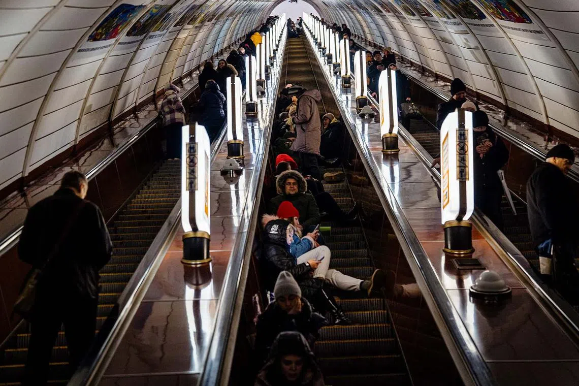 TOPSHOT - Civilians take shelter inside a metro station during air raid alert in the centre of Kyiv on December 13, 2022, amid the Russian invasion of Ukraine. (Photo by Dimitar DILKOFF / AFP)
