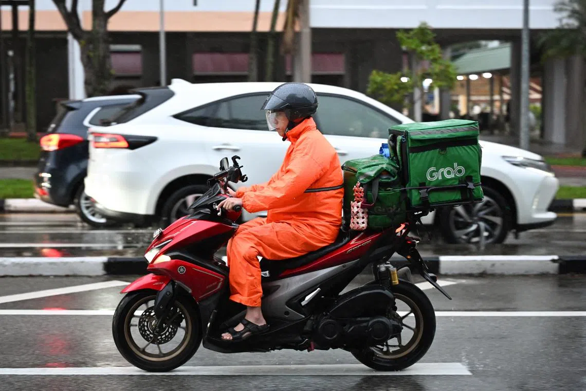 ST20240104-202486045088-Lim Yaohui-pixgeneric/
Grab delivery rider wearing raincoat riding along Tampines Avenue 3 outside St. Hilda's Primary School on a rainy day on Jan 4, 2024.
Can be used for stories on Grab, transport, food, and money.
(ST PHOTO: LIM YAOHUI)