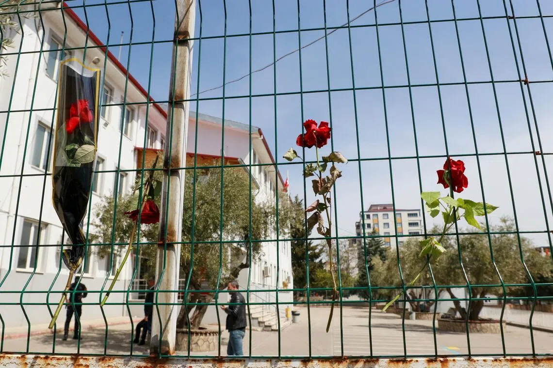 Flowers are hung on the fence of a school where a shooting took place yesterday, in the south-eastern province of Kahramanmaras, Turkey, on April 16.