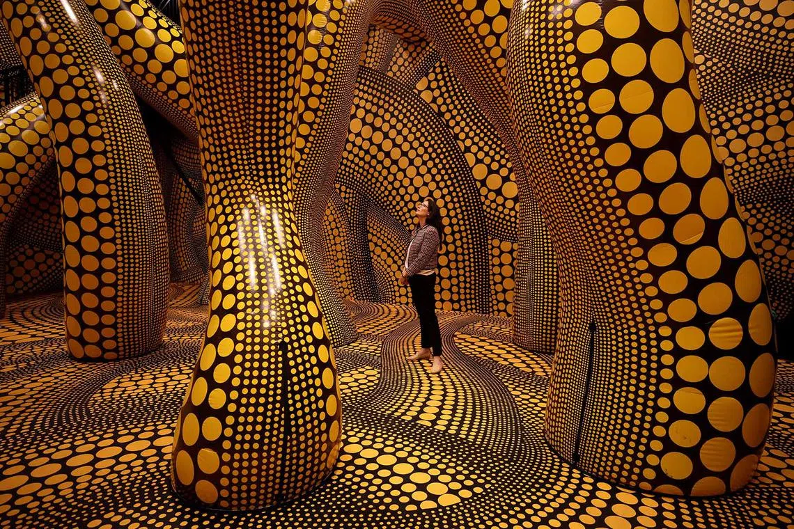 A visitor walks through a part of Japanese artist Yayoi Kusama's installation "You, Me and The Balloons" during a preview ahead of the start of the Manchester International Festival in Manchester, Britain, June 29.