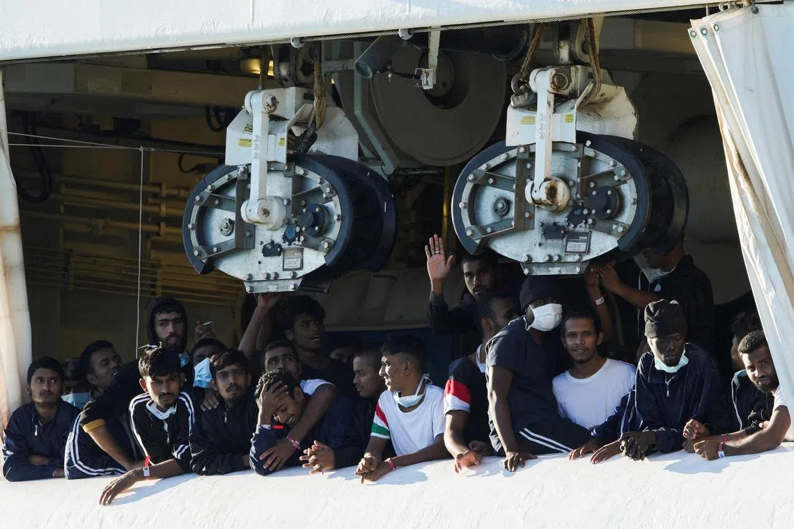 FILE PHOTO: Migrants look on as they stay on the rescue ship Geo Barents, after Italy allowed the disembarkation of children and sick people, in the port of Catania, Italy, November 7, 2022. 
