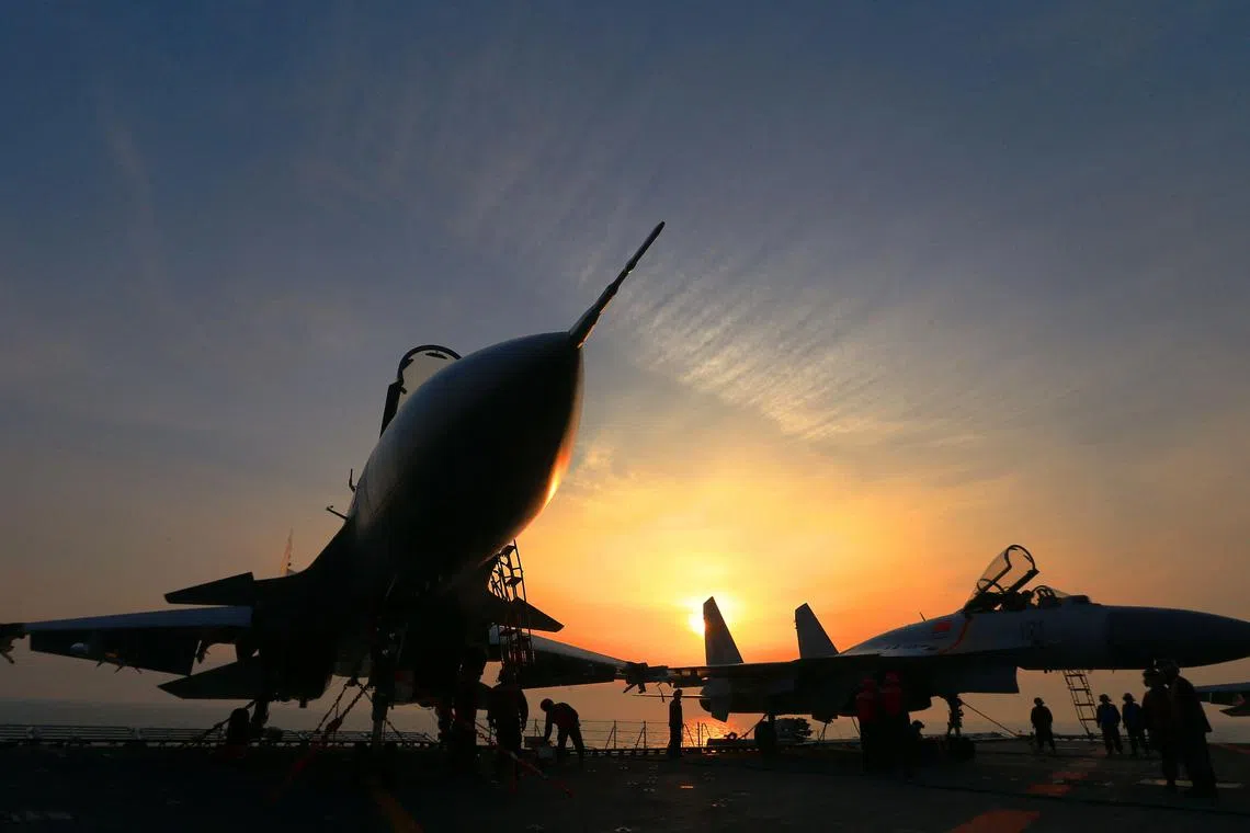 (FILES) This file photo taken on April 24, 2018 shows J15 fighter jets on China's operational aircraft carrier, the Liaoning, during a drill at sea. - During Xi Jinping's decade-long rule China has built the world's largest navy, revamped the world's largest standing army and amassed a nuclear and ballistic arsenal to trouble any foe. (Photo by AFP) / China OUT / TO GO WITH China-Xi-congress-military-Asia Pacific, FOCUS by Andrew BEATTY