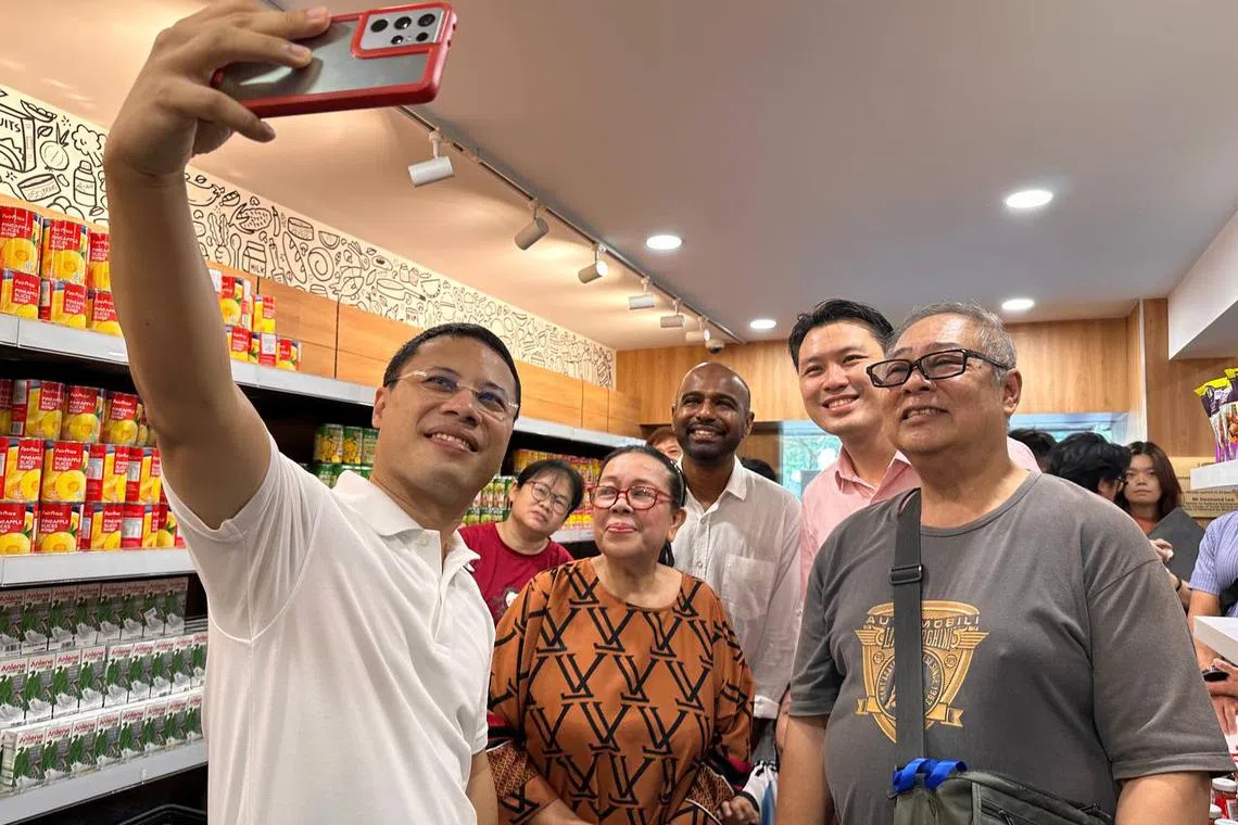 Minister for National Development Desmond Lee (far left), Mr Shawn Huang (in pink) and Dr Hamid Razak (centre) greet residents at the Community Shop @ Boon Lay on April 25.