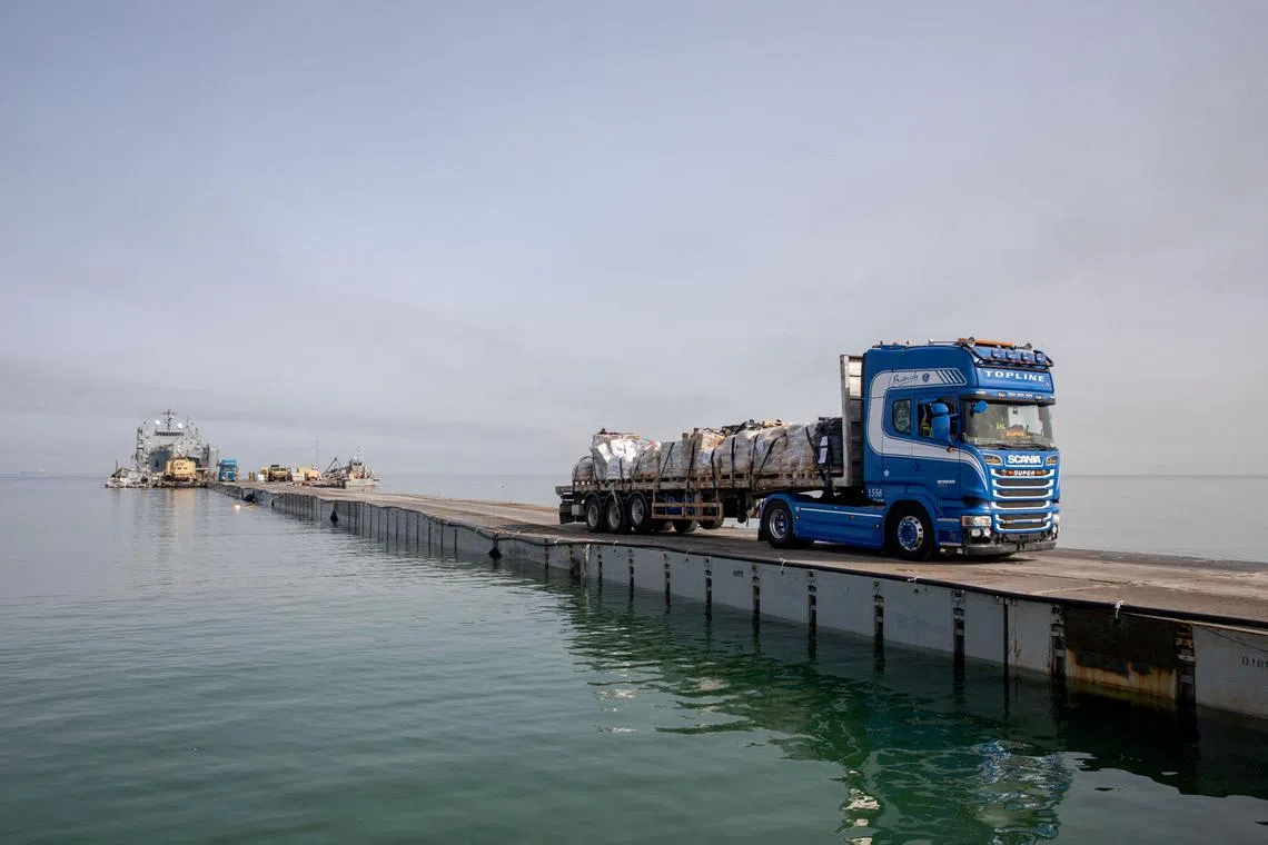 FILE PHOTO: A truck carries humanitarian aid across Trident Pier, a temporary pier to deliver aid, off the Gaza Strip, amid the ongoing conflict between Israel and the Palestinian Islamist group Hamas, near the Gaza coast, May 19, 2024. U.S. Army Central/Handout via REUTERS/File Photo