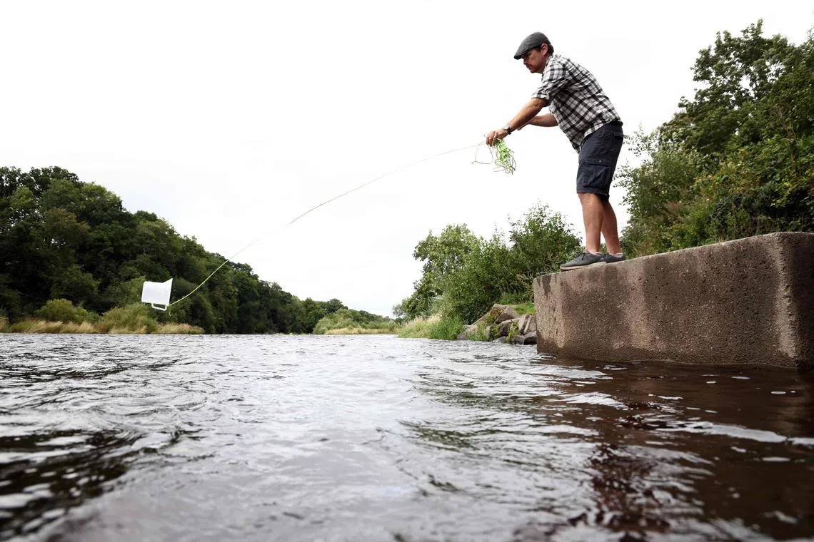 Citizen scientist Pat Stirling collects water from Britain's River Wye to check its quality.