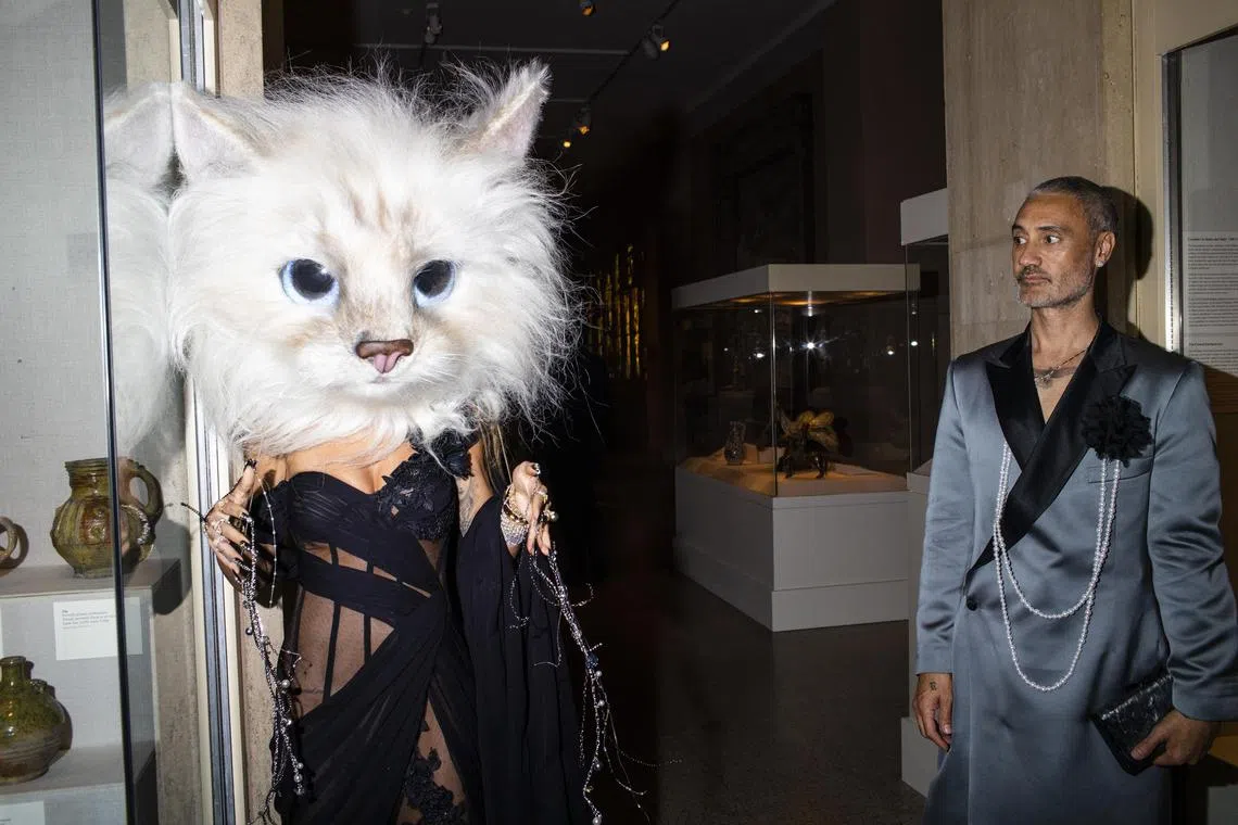 Taika Waititi looking on as Rita Ora wears Jared LetoÕs cat head at the Metropolitan Museum of Art's Costume Institute benefit gala in New York on May 1, 2023.