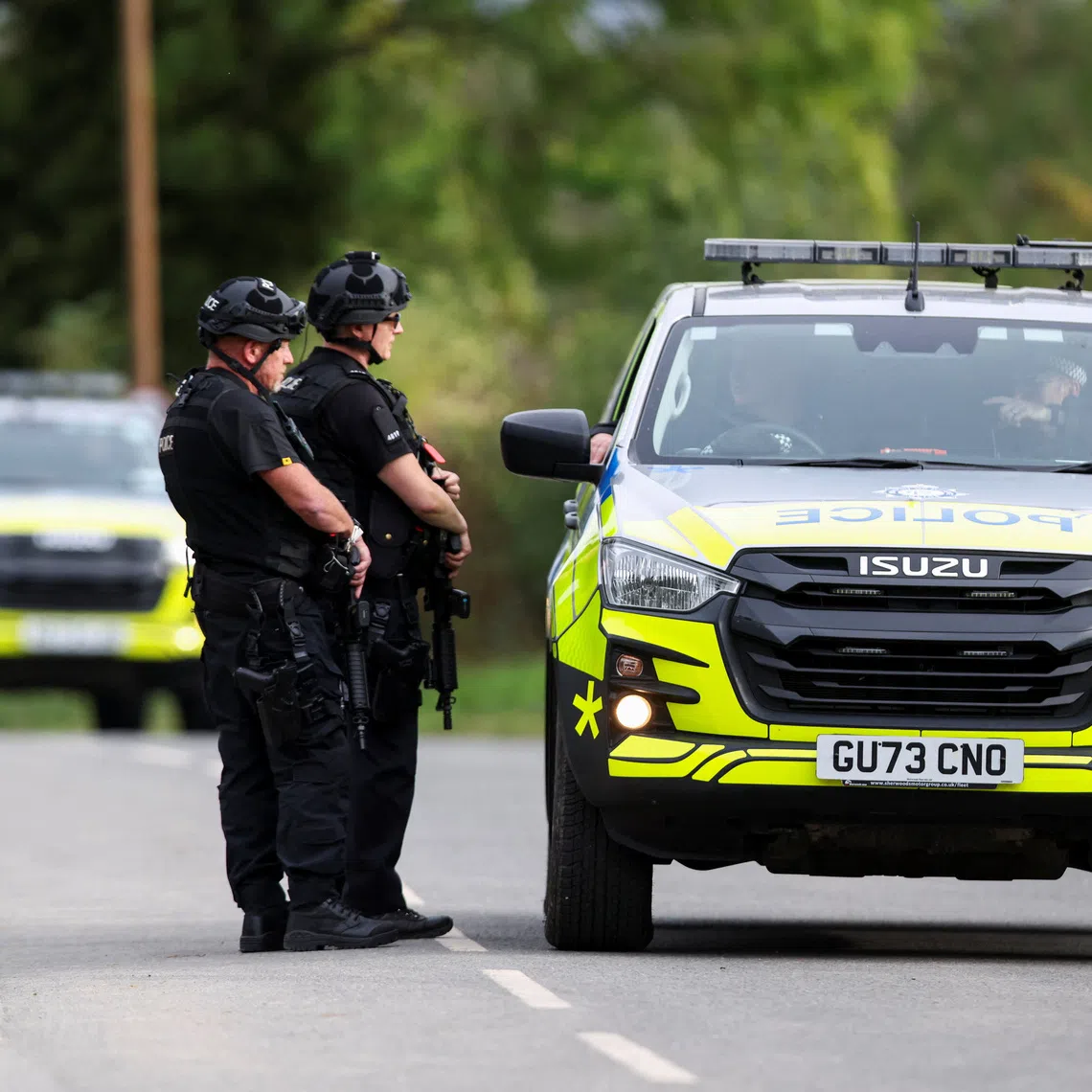 Armed police officers work on a road outside the perimeter of the RAF Fairford airbase, after police declared a major incident at the base, in Fairford, Gloucestershire, Britain, on Sept 28.