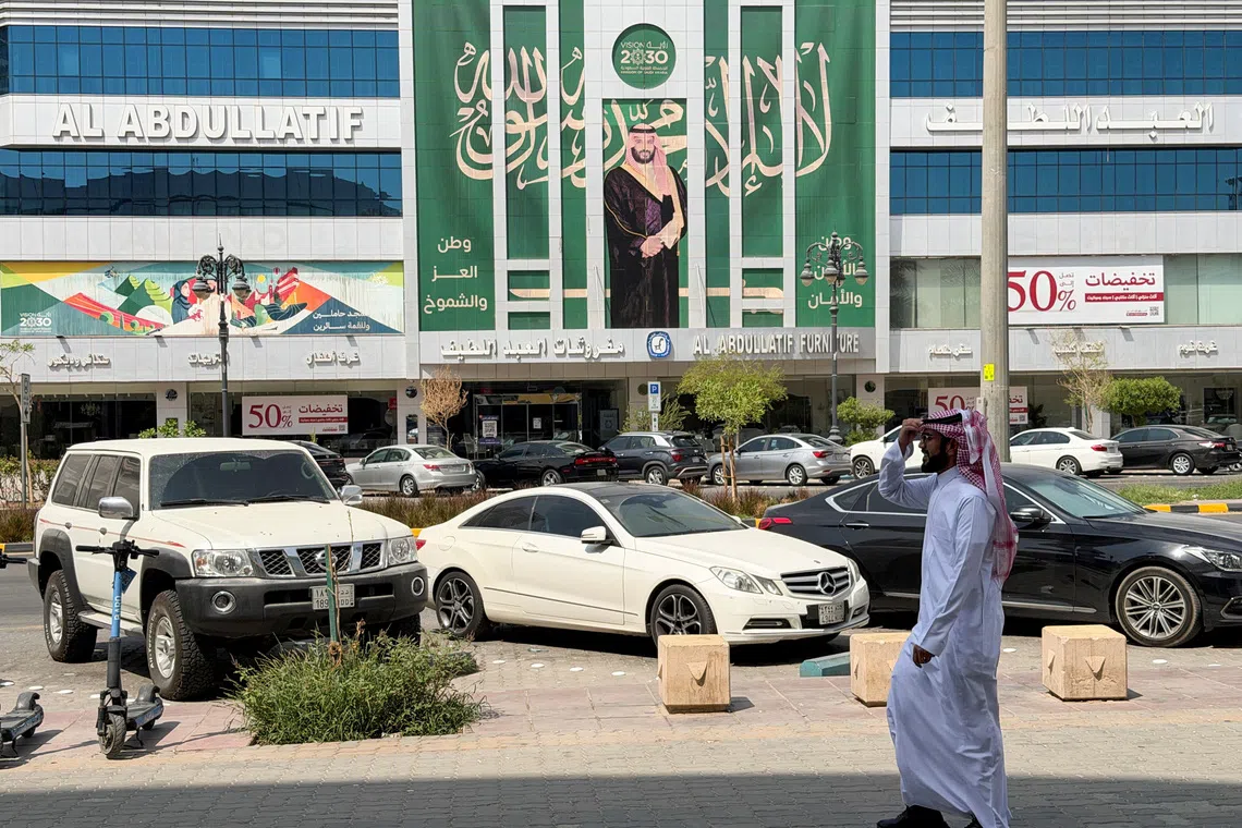 A Saudi man walks past a banner of Saudi Crown Prince Mohammed bin Salman displayed on a commercial building in Riyadh, Saudi Arabia, October 15, 2026. Picture taken with a mobile phone. REUTERS