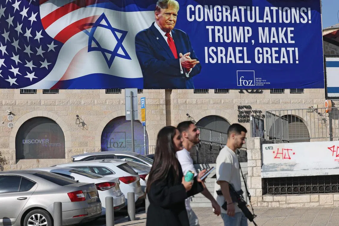 Israelis walking past a billboard congratulating US President-elect Donald Trump on his election win, in Jerusalem, on Nov 8.