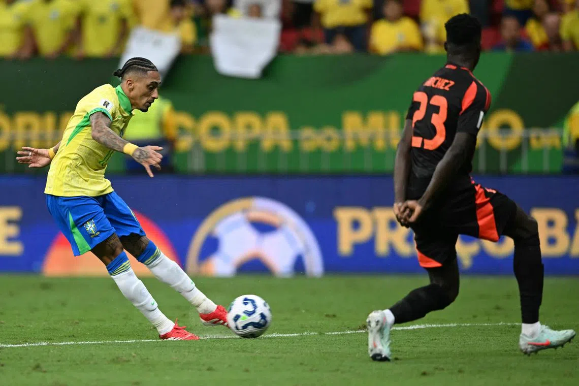 Brazil's forward #11 Raphinha kicks the ball past Colombia's defender #23 Davinson Sanchez during the 2026 FIFA World Cup South American qualifiers football match between Brazil and Colombia, at the Mane Garrincha stadium in Brasilia, on March 20, 2025. (Photo by EVARISTO SA / AFP)