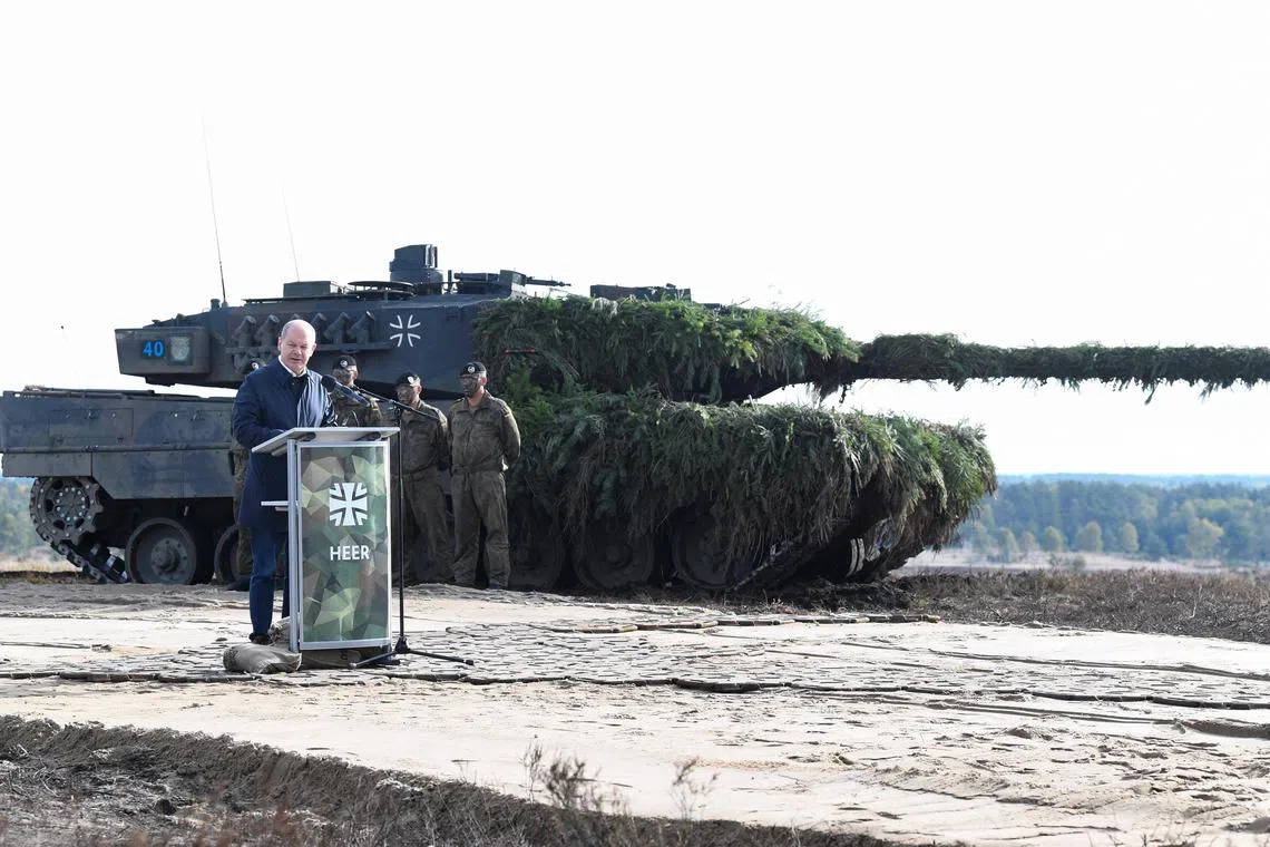 German Chancellor Olaf Scholz delivers a speech in front of a Leopard 2 tank during a visit to a military base of the German army Bundeswehr in Bergen, Germany, October 17, 2022. REUTERS/Fabian Bimmer 