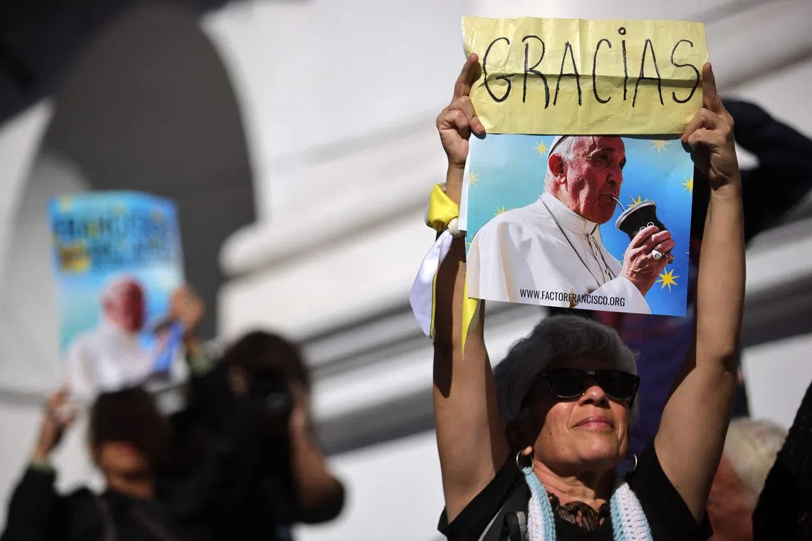 A woman holding a picture of Pope Francis with the word Gracias – Thank you in Spanish – during a mass to bid him farewell with songs, candles and flags in front of the Buenos Aires Cathedral on April 26, 2025. 