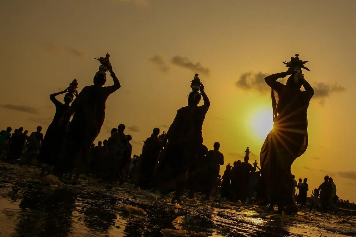 Indian fisherwomen of the Koli community in their traditional attire, performing rituals during the celebration of Narayali Purnima or Coconut Festival, at Manori beach in Mumbai, India, Aug 30.