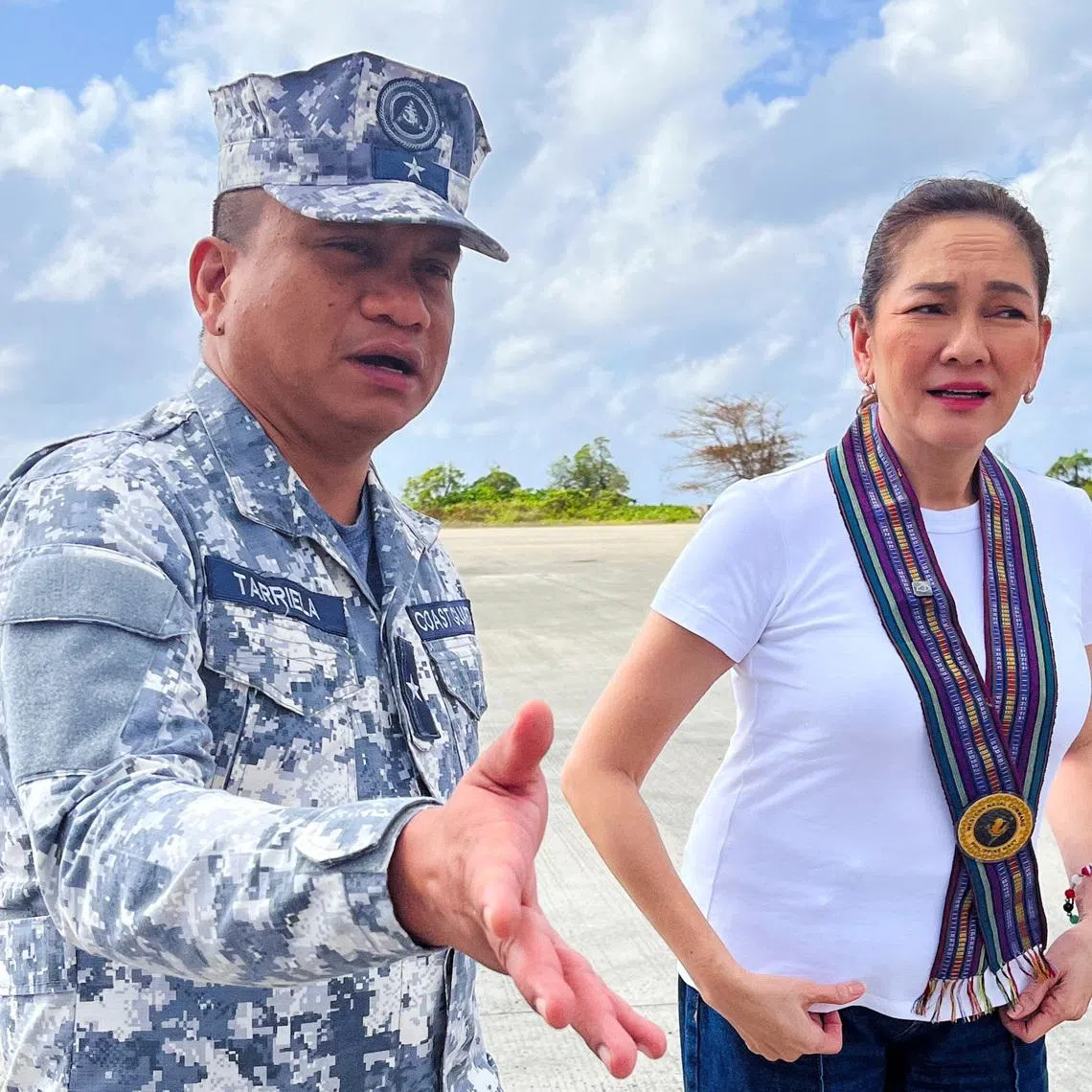 Philippine Coast Guard spokesperson Commodore Jay Tarriela gestures beside Philippine Senator Risa Hontiveros during a visit to Philippine-occupied Thitu Island in the disputed South China Sea, February 21, 2026. Picture taken with a mobile phone. REUTERS/Karen Lema