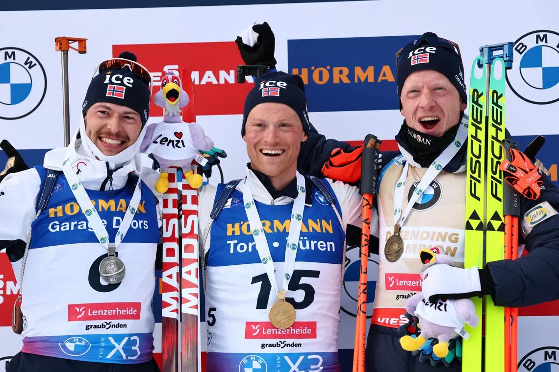 Winter Sports - Biathlon World Championships - Men 15km Mass Start Competition - Lenzerheide, Switzerland - February 23, 2025 Gold medallist Norway's Endre Stroemsheim celebrates on the podium during the Men 15km Mass Start Competition medal ceremony with silver medallist Norway's Sturla Holm Laegreid and bronze medallist Norway's Johannes Thingnes Boe REUTERS/Denis Balibouse