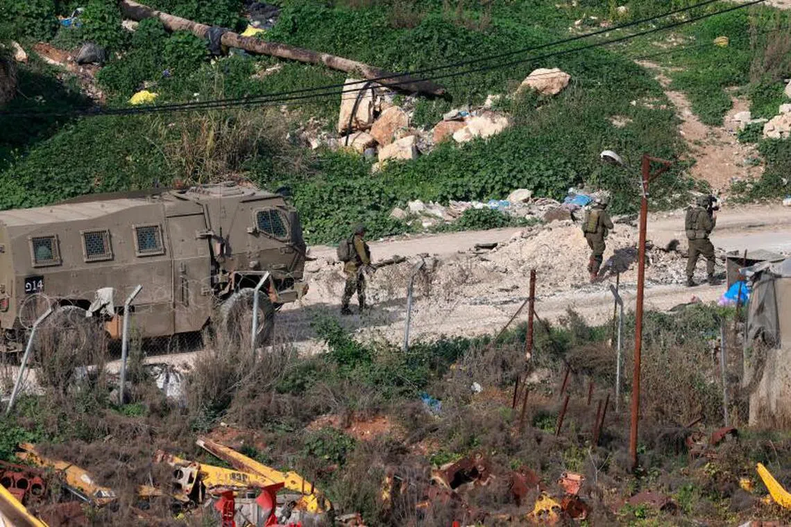Israeli soldiers walk along a road during a military raid in the al-Fara camp for Palestinian refugees, south of Jenin in the occupied West Bank on February 2, 2025. Israeli troops or settlers have killed at least 881 Palestinians, including many militants, in the West Bank since the start of the war in the Gaza Strip, according to the Palestinian health ministry. (Photo by Jaafar ASHTIYEH / AFP)
