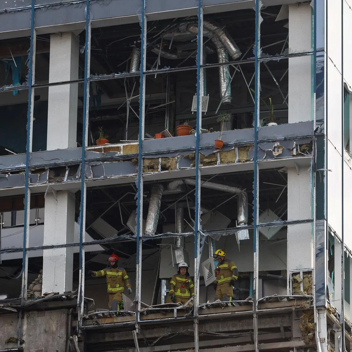 Rescuers working at an office building hit by a Russian drone, in Kyiv, Ukraine, on Sept 25.