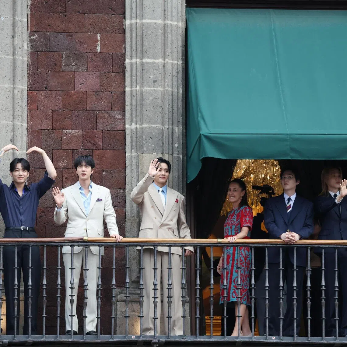 Mexico's President Claudia Sheinbaum and members of South Korean Kpop boy band BTS react as they stand on a balcony of the National Palace ahead of a series of concerts on the BTS World Tour "Arirang" in Mexico City, Mexico, May 6, 2026. REUTERS/Luis Cortes