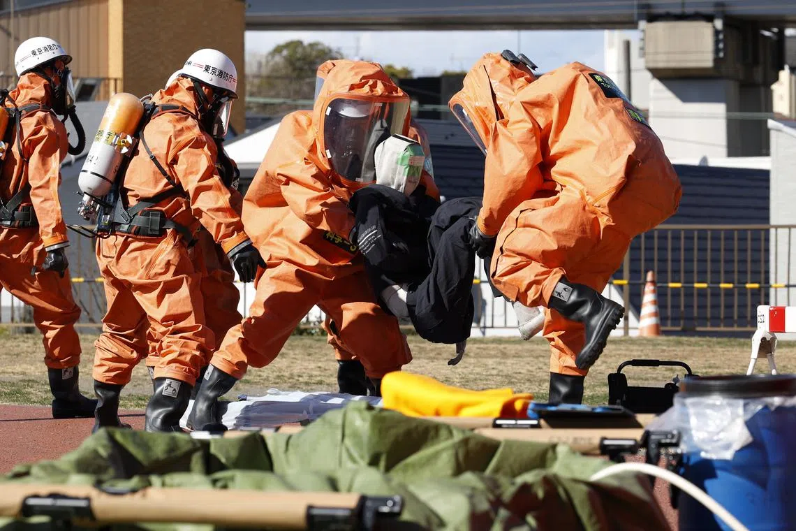 Firefighters in protective gear taking part in a drill simulating missile attack in Tokyo, on Feb 4.