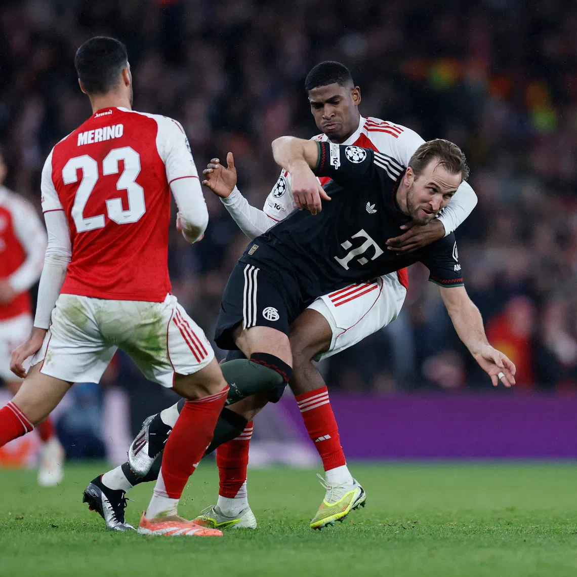 Soccer Football - UEFA Champions League - Arsenal v Bayern Munich - Emirates Stadium, London, Britain - November 26, 2025 Bayern Munich's Harry Kane in action with Arsenal's Cristhian Mosquera and Mikel Merino Action Images via Reuters/Peter Cziborra