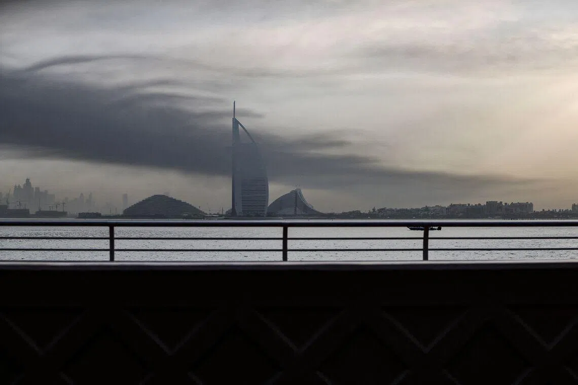 Smoke rises above Dubai on March 13, 2026. Explosions rattled buildings in Dubai and a large cloud of smoke hung over a central area of the Middle East financial hub on March 13, AFP correspondents said. (Photo by AFP) / 