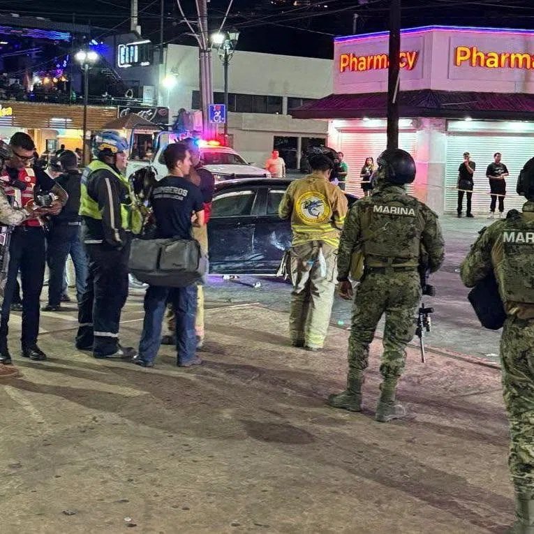 Security personnel and emergency responders stand at the site where a car rammed through a crowd of Mexico football fans.